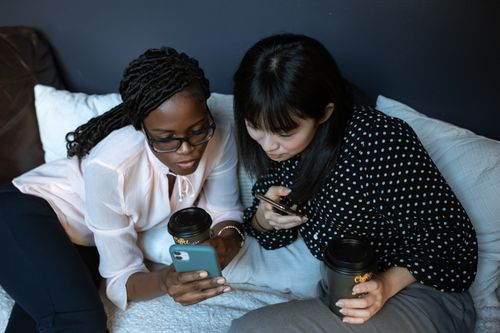 スマートフォンで写真を一緒に見る二人